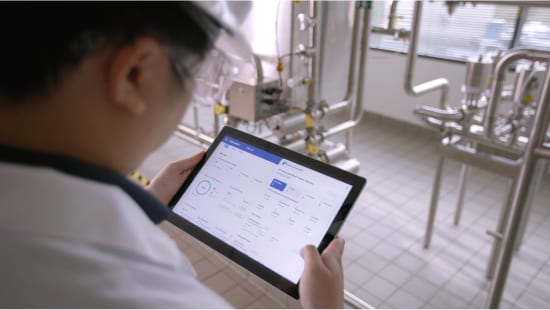 Ecolab expert reviewing data on CIP IQ tablet.