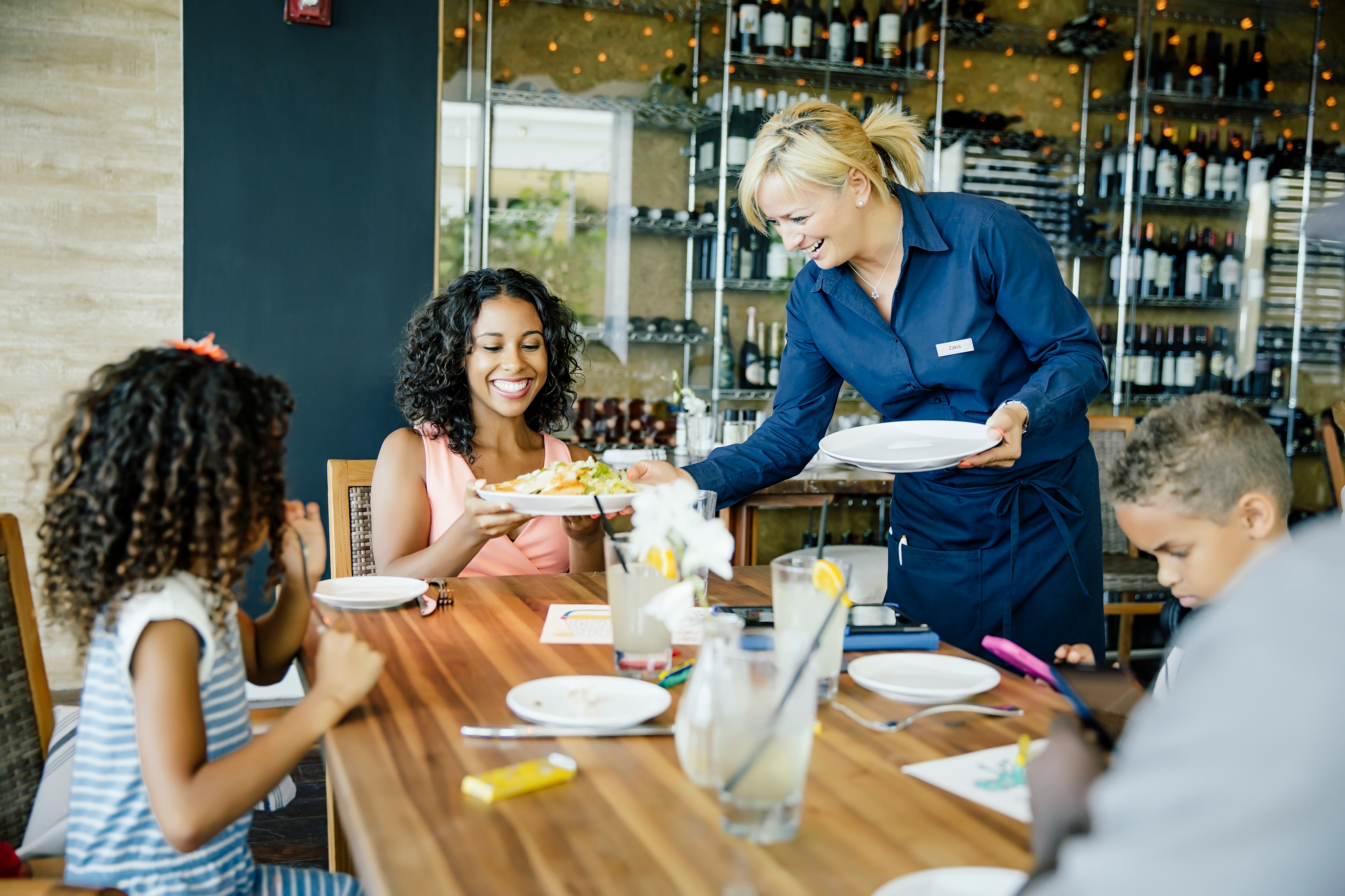 Guests being served at restaurant table.
